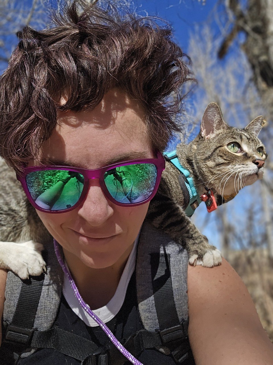 Alicia hiking outdoors with her cat Rascal riding on her shoulders